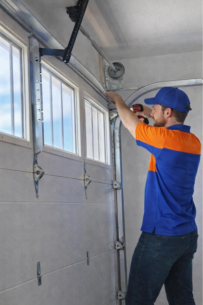 A technician replacing a damaged garage door panel Windsor, CO