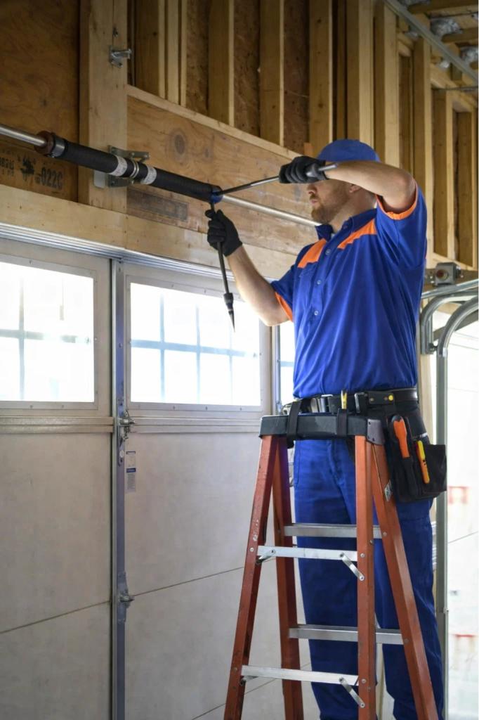 A licensed technician performing a garage door repair in Fort Collins, CO